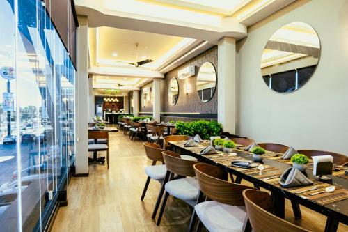 a restaurant with wooden tables and chairs and a large window at Esplendor by Wyndham Los Mochis Country Place in Los Mochis