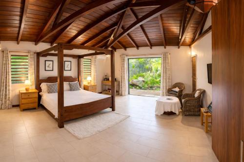 a bedroom with a canopy bed in a room at Cinnamon Room Four-Poster Bed, Freestanding Bath, Walk-In Shower & Infinity Pool in Cap Malheureux