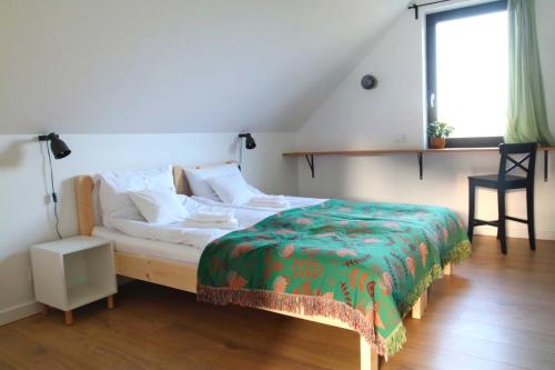 a bedroom with a bed with a green blanket on it at Smugi Dom Gościnny in Lipowiec