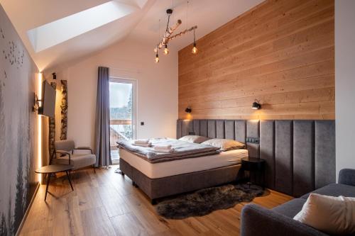 a bedroom with a bed and a wooden wall at RESORT JEZERNÍ Apartmány & Penzion Wellness in Železná Ruda