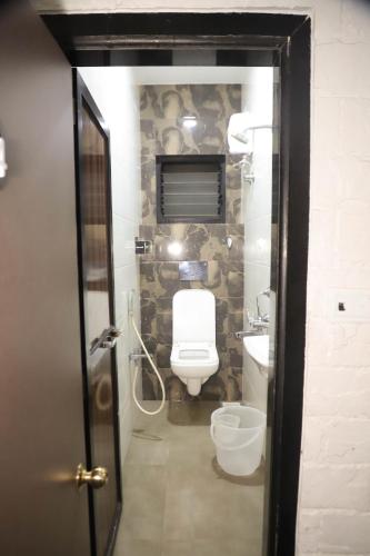 a bathroom with a toilet and a sink at Hotel Maharaja in Thane