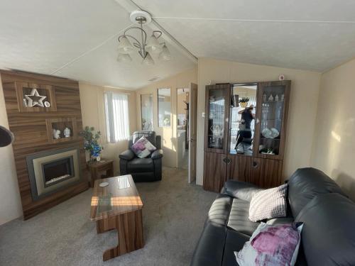 a living room with a couch and a fireplace at Large family holiday home in Gunton