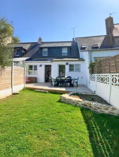 a house with a patio with a table in the yard at Superbe maison 85m2 - Plages à 2km - Jardin clos - Maison Kaerell in Billiers
