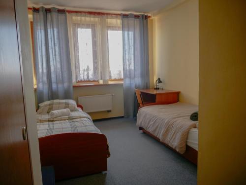 a bedroom with two beds and a window at Hotel Sowa in Częstochowa