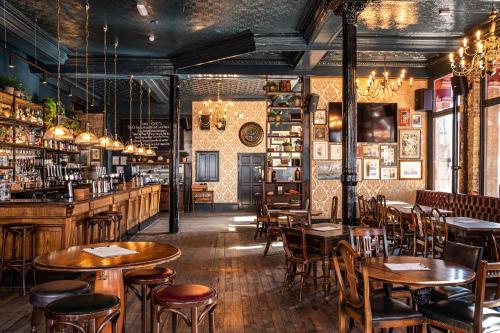 a restaurant with tables and chairs and a bar at The Red Lion Hotel in London
