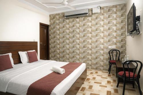 a bedroom with a bed and a table with a chair at Hotel Majestica 22 in Chandīgarh