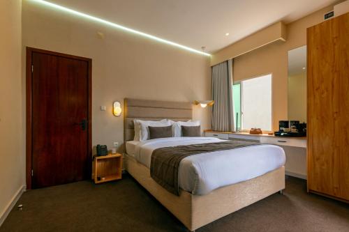 a hotel room with a large bed and a window at Kululwa House in Luanda