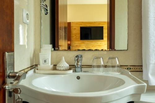 a white sink in a bathroom with a mirror at Kululwa House in Luanda