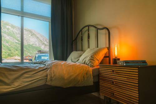 a bedroom with a bed next to a window at Frafjord Apartments Frøya in Dirdal