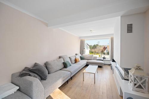 a living room with a couch and a tv at Summer Dream in De Haan