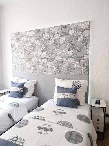 ein Schlafzimmer mit zwei Betten und einem Kopfteil mit Blumen in der Unterkunft MonAppart in Gera