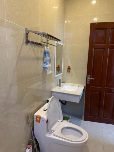 a bathroom with a white toilet and a sink at Carol Dalat in Khu Chi Lăng