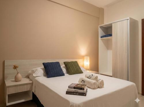 a bedroom with a large white bed with blue and green pillows at Residence Cumbuco Paradise Beach in Cumbuco