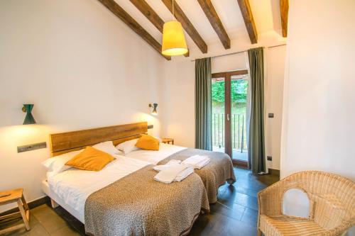 a bedroom with two beds and a chair in it at Espectacular casa rural en el corazón del Baztán in Ziga