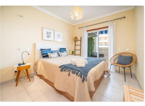 a bedroom with a large bed with blue pillows at Sunny apartamento in Portimão