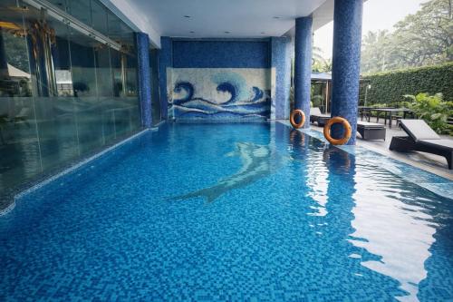 a swimming pool with a shark in the water at Hotel Saj Luciya in Trivandrum