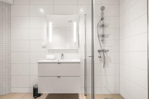 a white bathroom with a sink and a shower at Prime Location - 2 Bedroom Apartment! in Bergen