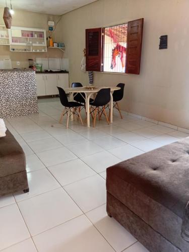 a kitchen and living room with a table and chairs at BELL MAR CHALéS 05 in Luis Correia