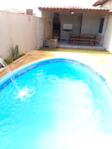 a blue swimming pool with a water fountain at BELL MAR CHALéS 05 in Luis Correia