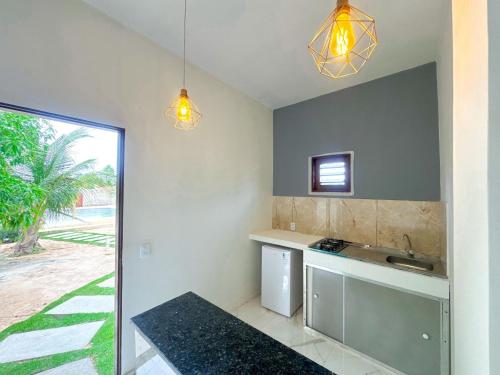 a kitchen with a sink and a counter at Apart hotel Refúgio tropical Icarai de amontada in Amontada