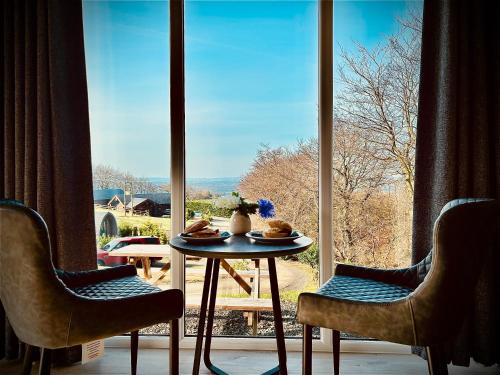 a table and chairs in front of a large window at The Vu Snugs in Bathgate