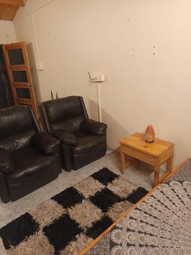 a living room with a leather couch and a table at Harmal's Residency in Arambol