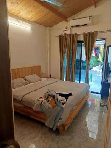 a bedroom with a bed and a window at Harmal's Residency in Arambol