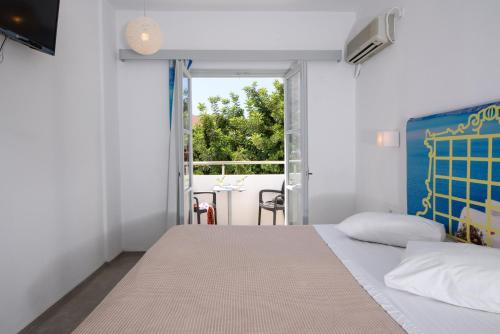 a bedroom with a bed and a large window at RK Beach Hotel in Kamari