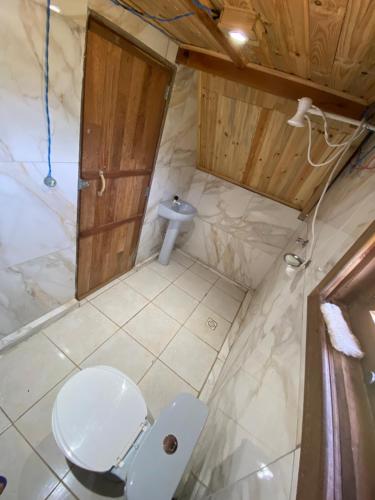 a bathroom with a toilet and a sink at Abrigo Pedrão in Pedralva