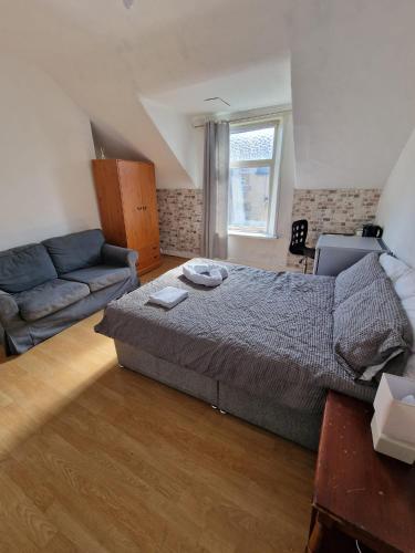 a bedroom with a bed and a couch at Princess Homestay in Sunderland