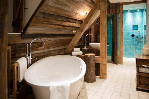 a bathroom with a large tub and two sinks at Posthotel Alexander Herrmann in Wirsberg