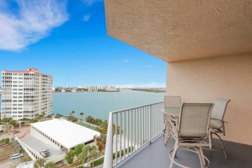 a balcony with two chairs and a view of a body of water at Lovers Key Resort 1107 in Fort Myers Beach