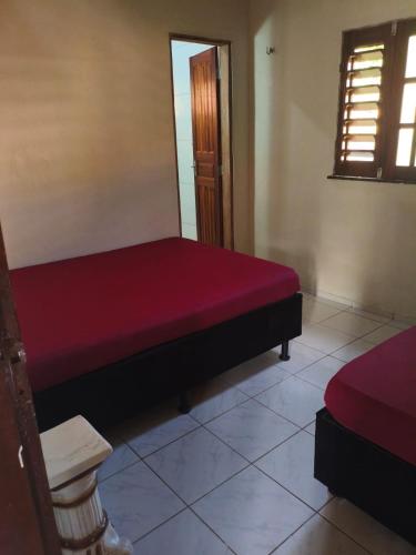 a bedroom with a red bed in a room at Chalé Triunfo in Pacoti