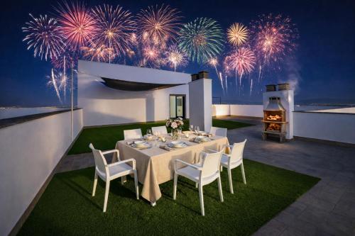 a dining room with a table and fireworks at Áticos Lux Sevilla Piscina Parking in Bormujos