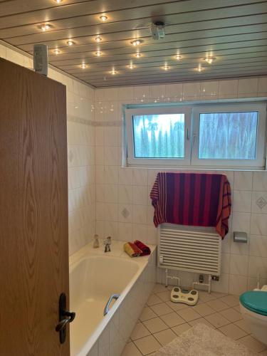 a bathroom with a bath tub and a window at Harmonie im Grünen - Charmantes Erdgeschoss Privatzimmer mit Gartenzugang in Wathlingen
