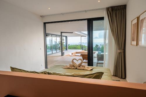 a bedroom with a bed with a large glass window at Titine Villa in Srithanu