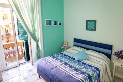 ナポリにあるヴィアッジョ ア ナポリ B＆Bのベッドルーム1室(青いヘッドボード付きのベッド1台、窓付)