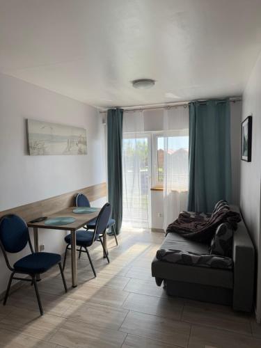 a bedroom with a bed and a table and chairs at Pensjonat SYRENA in Krynica Morska