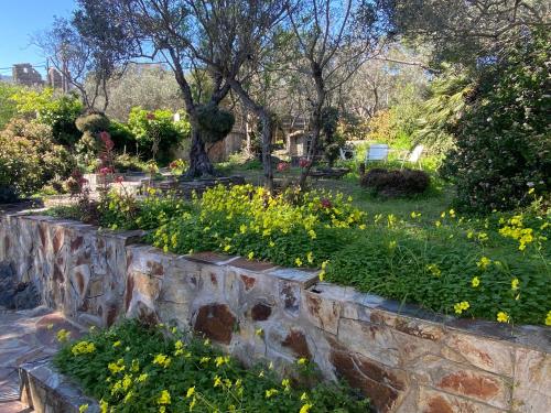 a retaining wall in a garden with flowers at La Caseta de Cadaqués in Cadaqués