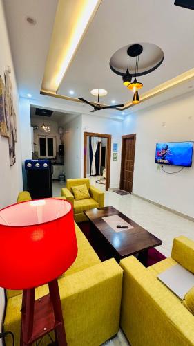 a living room with yellow couches and a red chair at Warm Nest in Dehradun