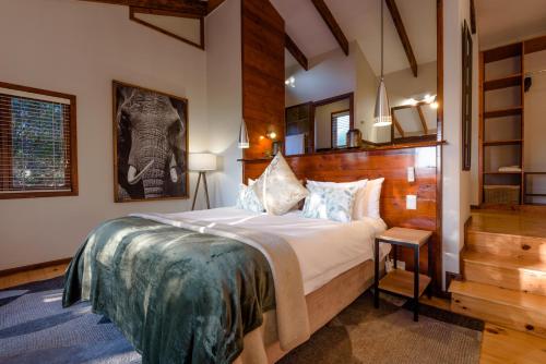 a bedroom with a large bed and a staircase at Elephant Hide of Knysna Guest Lodge in Knysna
