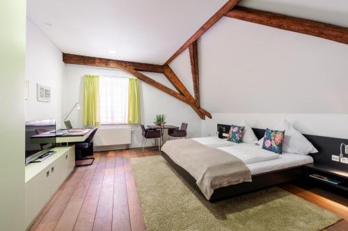 a bedroom with a large bed and a desk at Buhlsche Mühle in Ettlingen