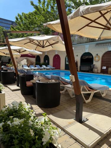 ein Schwimmbecken mit Stühlen und Sonnenschirmen neben einem Pool in der Unterkunft Hotel Otrada in Odessa