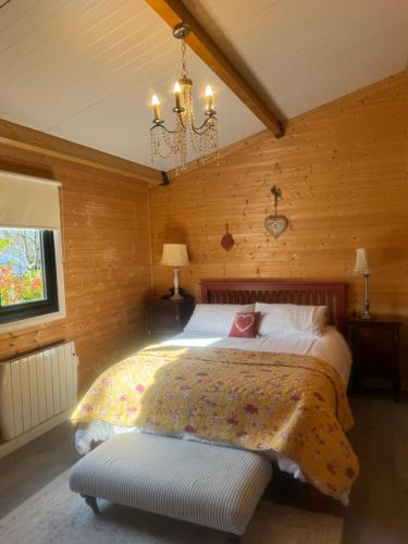 a bedroom with a large bed and a chandelier at Shabby Chic Barn in Galway