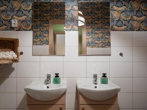 a bathroom with two sinks and two mirrors at Marinans Guesthouse in Nävekvarn