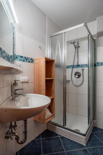 a bathroom with a sink and a shower at Julius Appartements & Zimmer in Wagrain