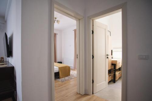 a bedroom with a door open to a room with a bed at ASTI Residence Aparthotel in Năvodari