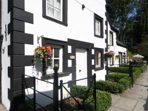a white building with black windows and flowers on it at Sherrifs Lodge - Hw7730 in Llangadog