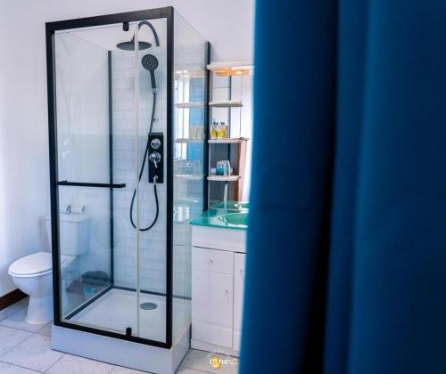 a bathroom with a shower with a glass door at Le Clos de Ébéniers in Saint-Laurent du Maroni