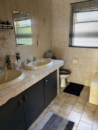 a bathroom with two sinks and a toilet at Cloete Self Catering Sky Room in Ermelo
